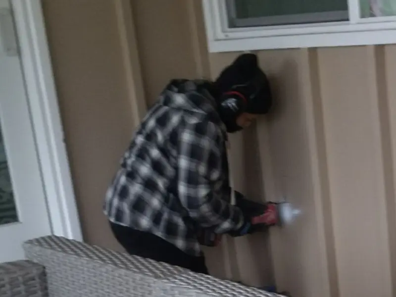 Professional electrician installing an exterior outlet in Wall